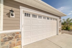 A white garage door in front of a house.