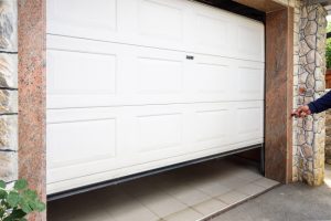 A white garage door is open and has a handle.